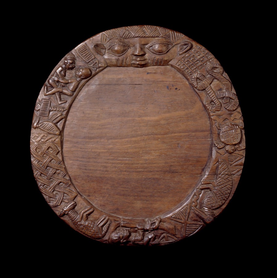 Yoruba Ifa divination board (opon Ifa) with carved border featuring the face of Eshu and intricate geometric and figurative motifs